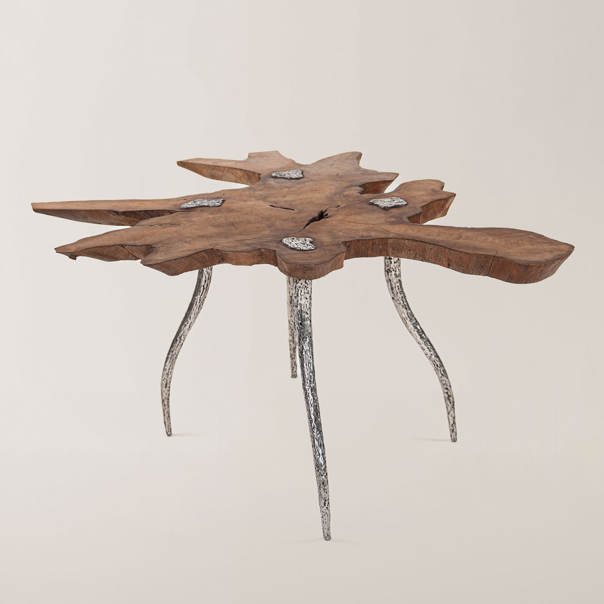  Einzigartiger handgefertigter Tisch aus Teakholz, dessen Oberfläche organische, unregelmäßige Formen aufweist, mit geschwungenen Beinen aus geschweißtem Metall, die ein kunstvolles Design haben.